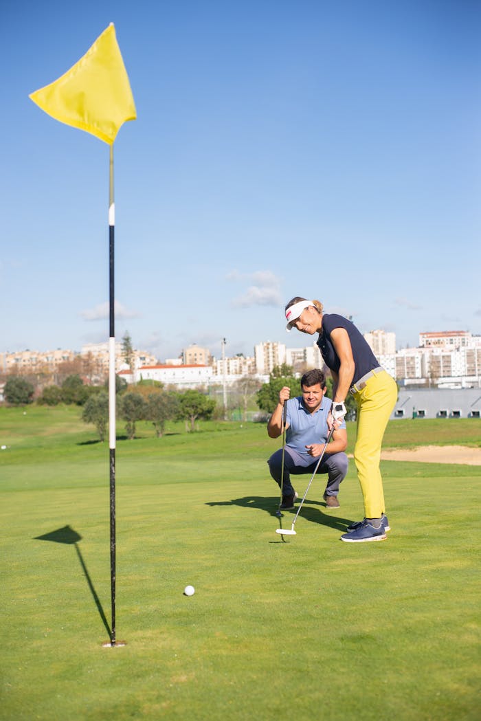 Golfers practicing putting on a sunny day with a city backdrop in Portugal.